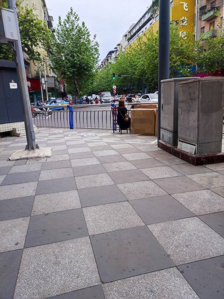 商机来了!老火车站外面那个十字路口有人在人行道上卖头盔.