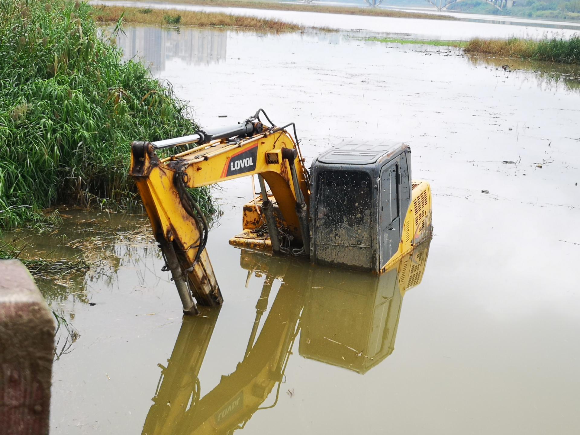 资阳一挖机在沱江边作业,不慎陷入泥潭中