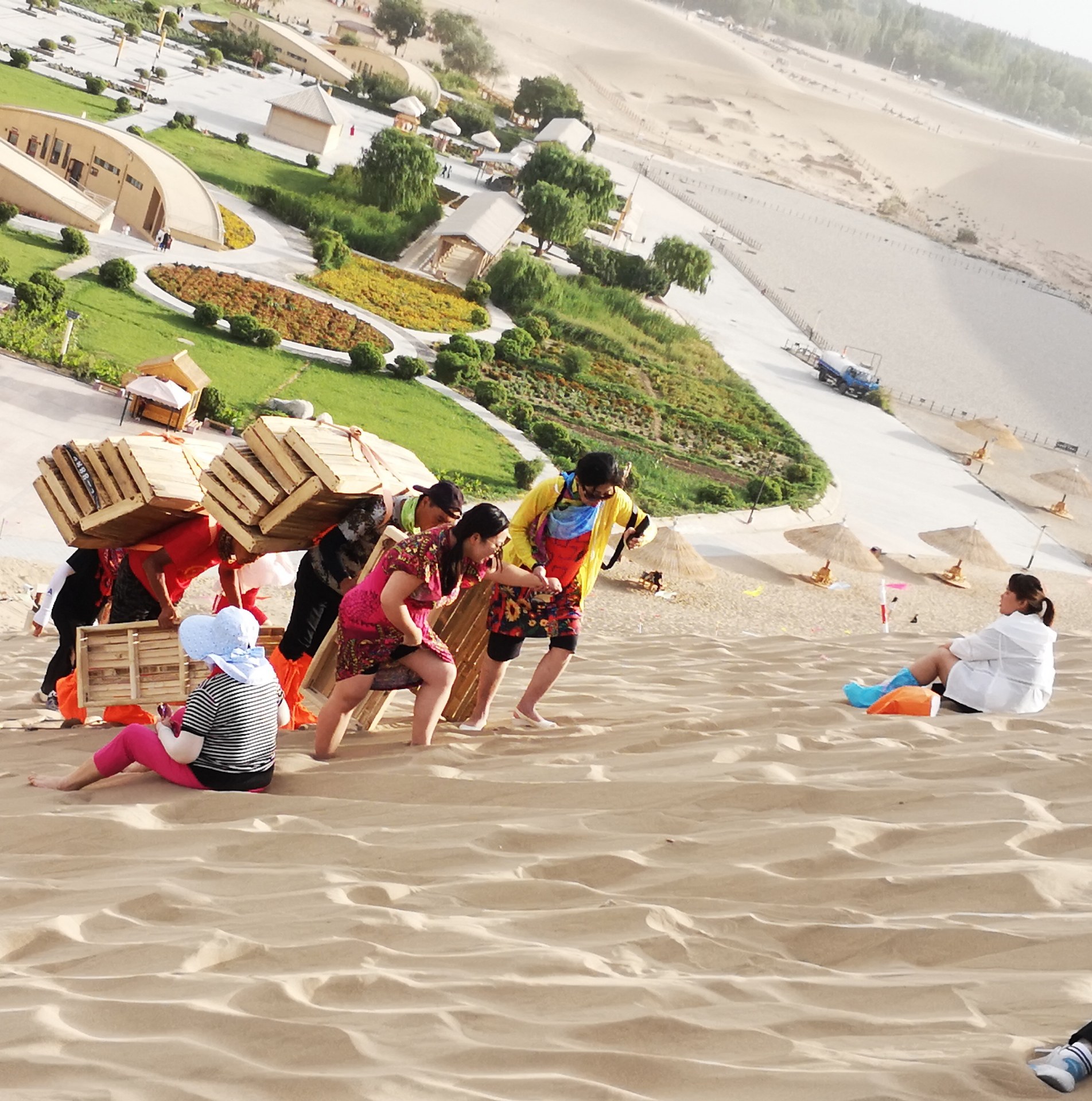 敦煌鸣沙山滑沙很好玩,可滑板要背上山却非常艰辛