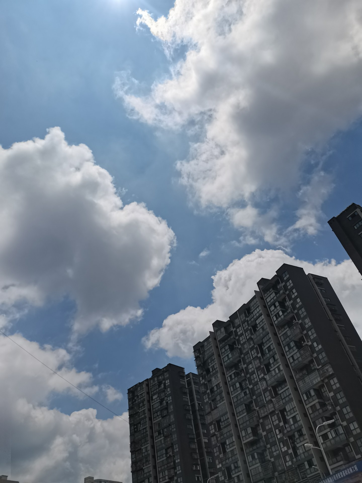 抬起頭來,仰望天空 藍天白雲,晴空萬里 午間太陽,光芒四射 高樓大廈