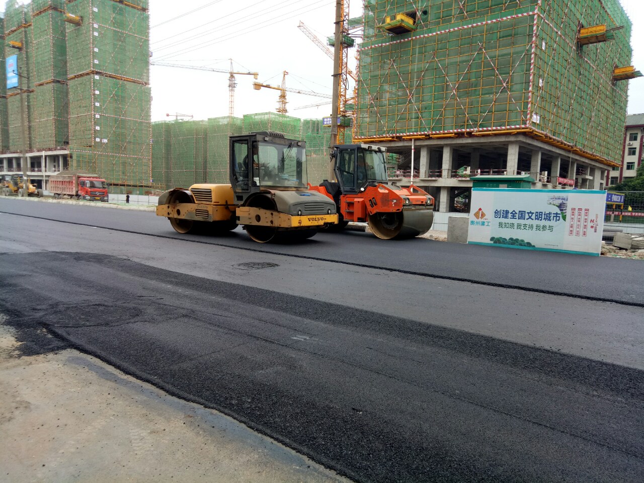 资阳南门口至梅西百货正在铺设沥青混凝土,引不少群众围观