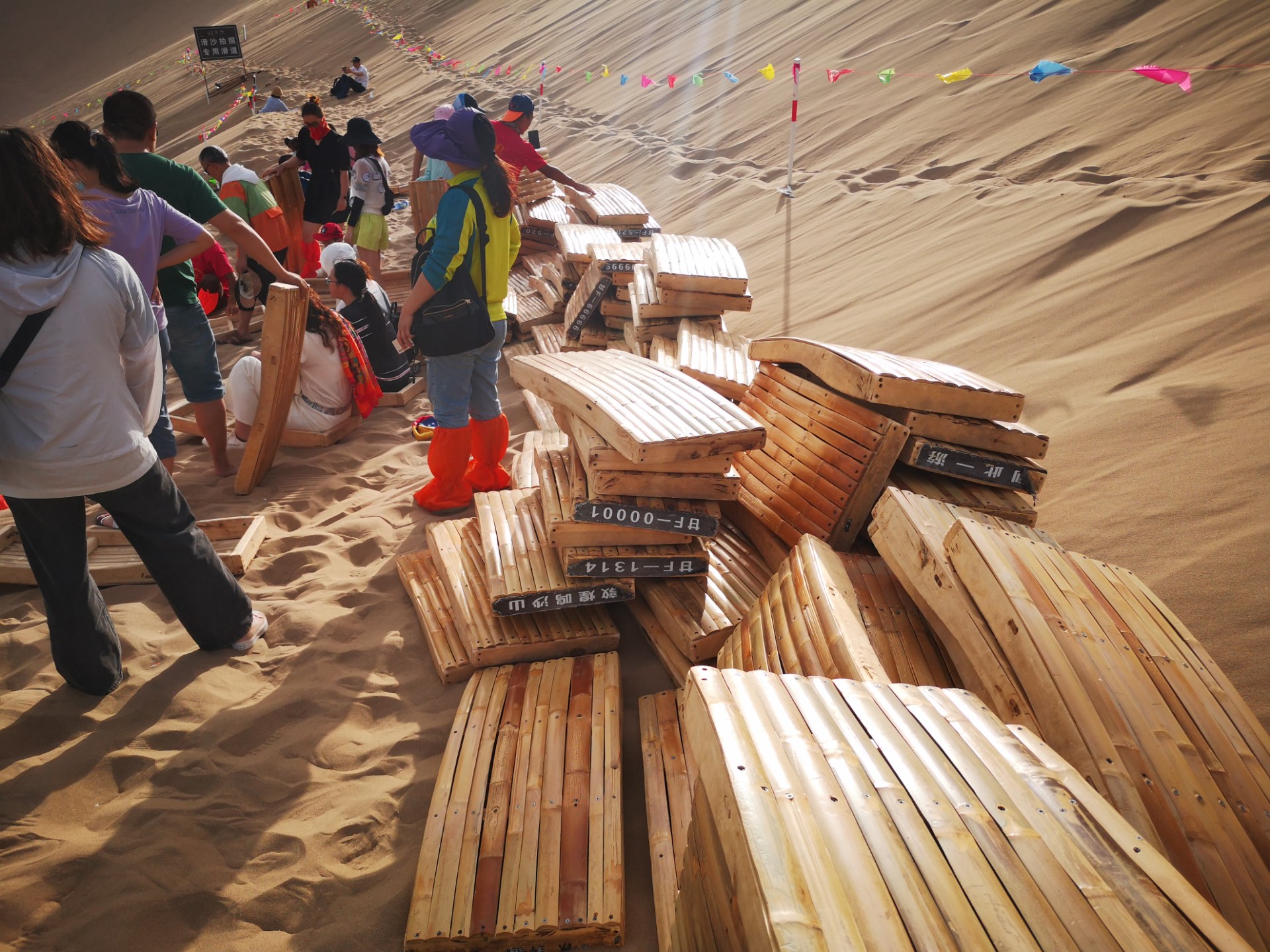 敦煌鸣沙山滑沙很好玩,可滑板要背上山却非常艰辛