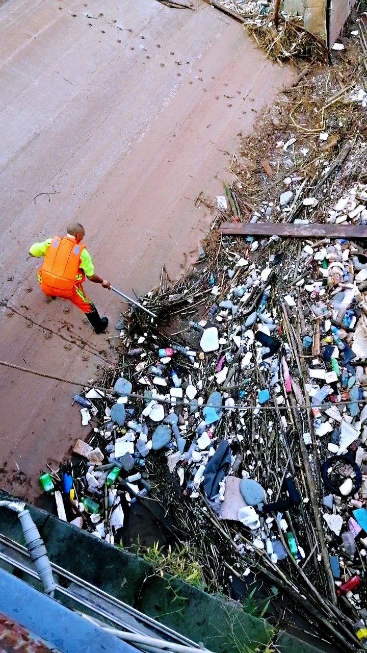 一场洪水给资阳九曲河带来许多的垃圾,加大了环卫工人的清捞压力!