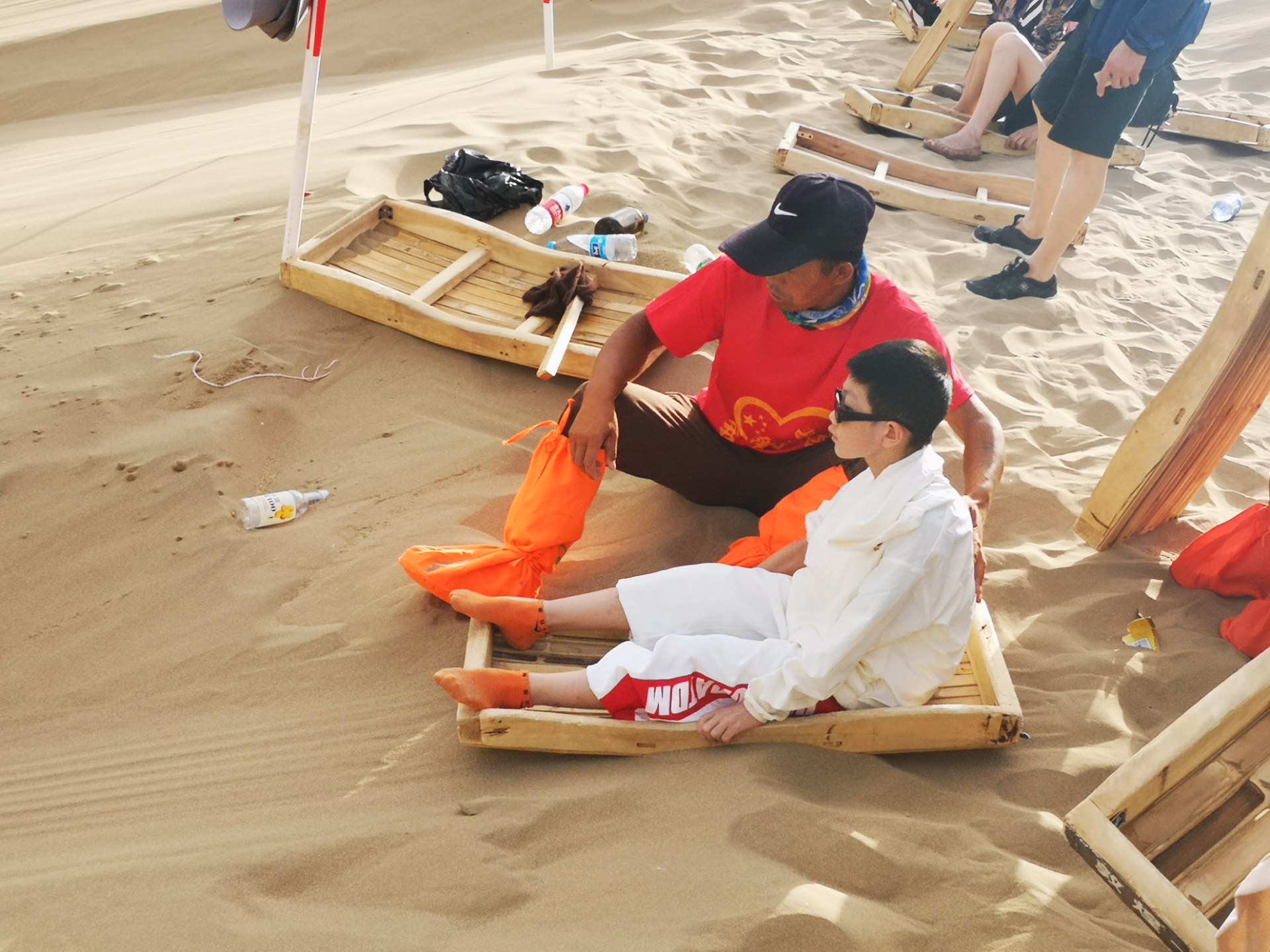 敦煌鸣沙山滑沙很好玩,可滑板要背上山却非常艰辛